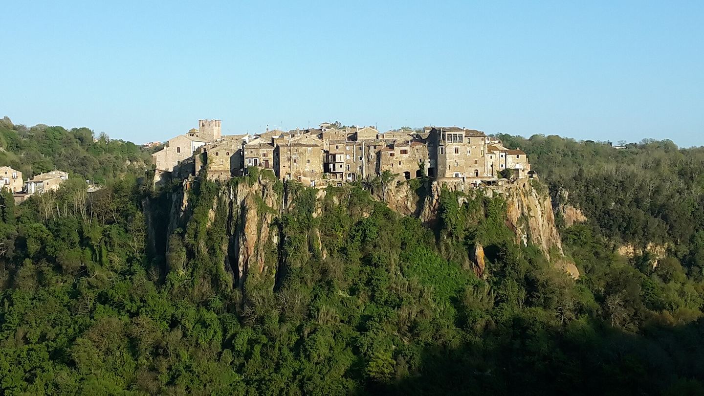 Calcata Vecchia rising from a wooded volcanic outcrop