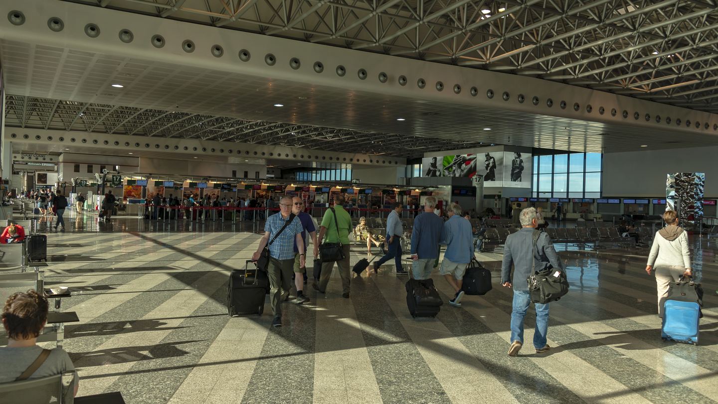 Travelers and check-in counters inside Milan Malpensa Airport
