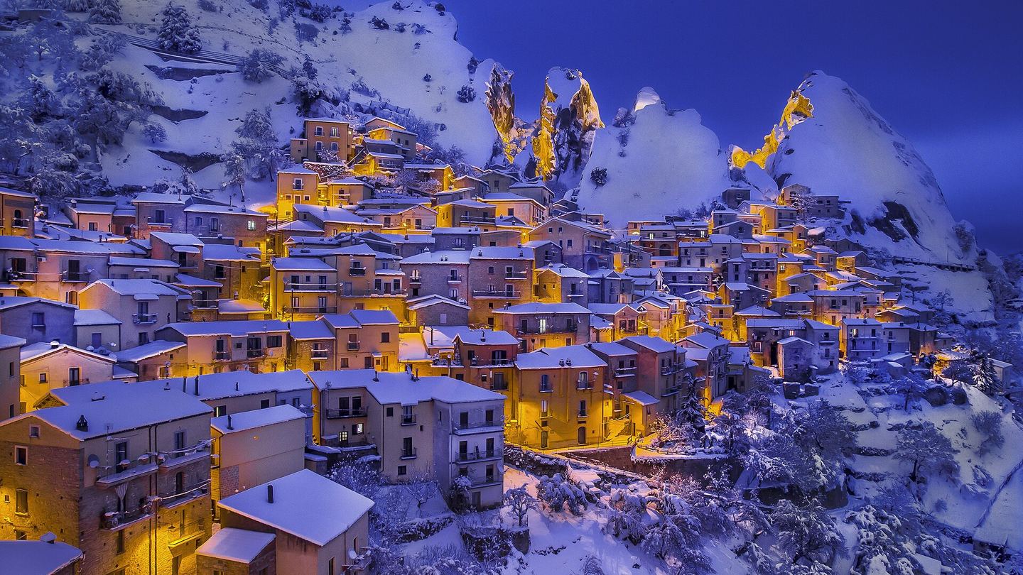 Castelmezzano lit at blue hour beneath the Lucanian Dolomites