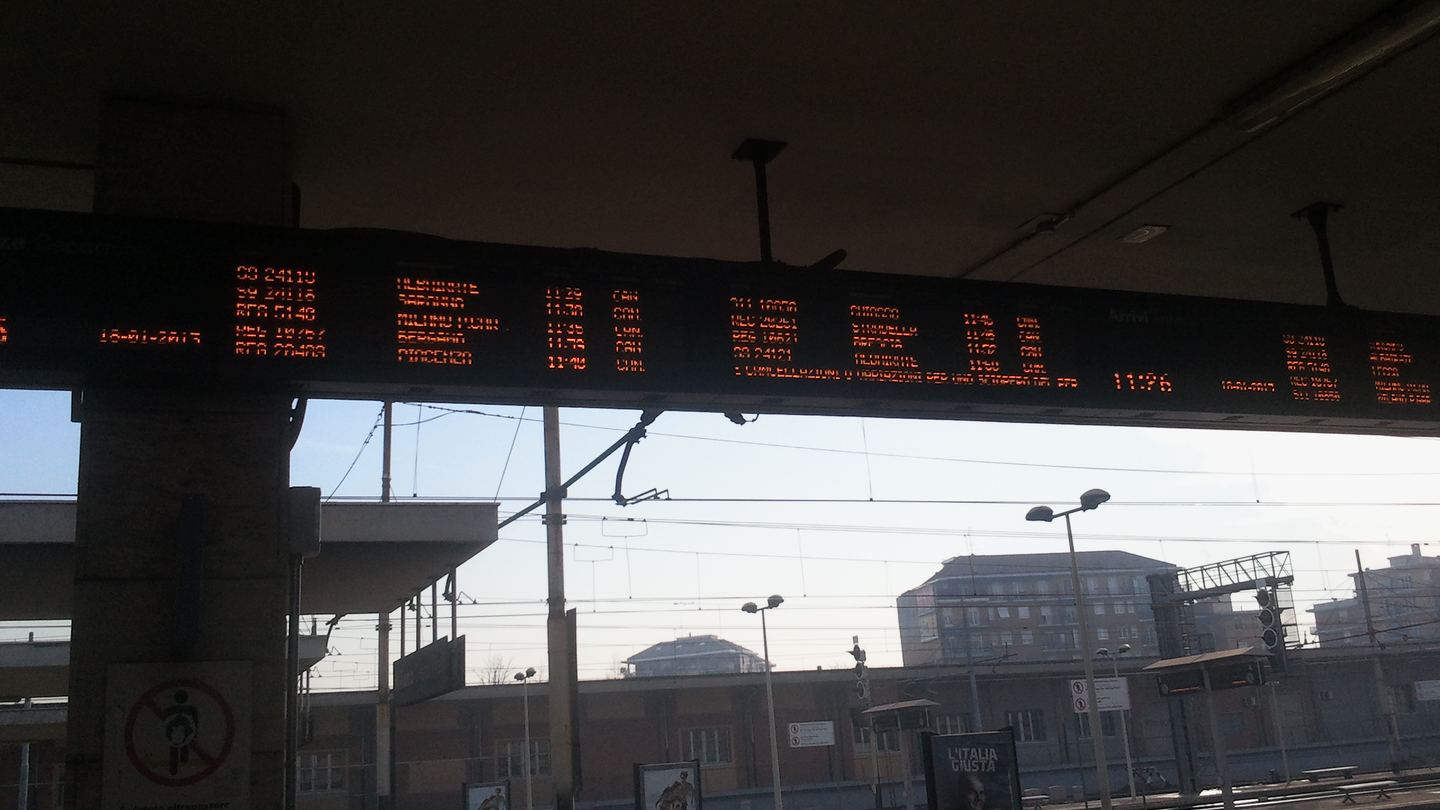 A departure board above nearly empty platforms at Milano Greco Pirelli during a Trenord strike