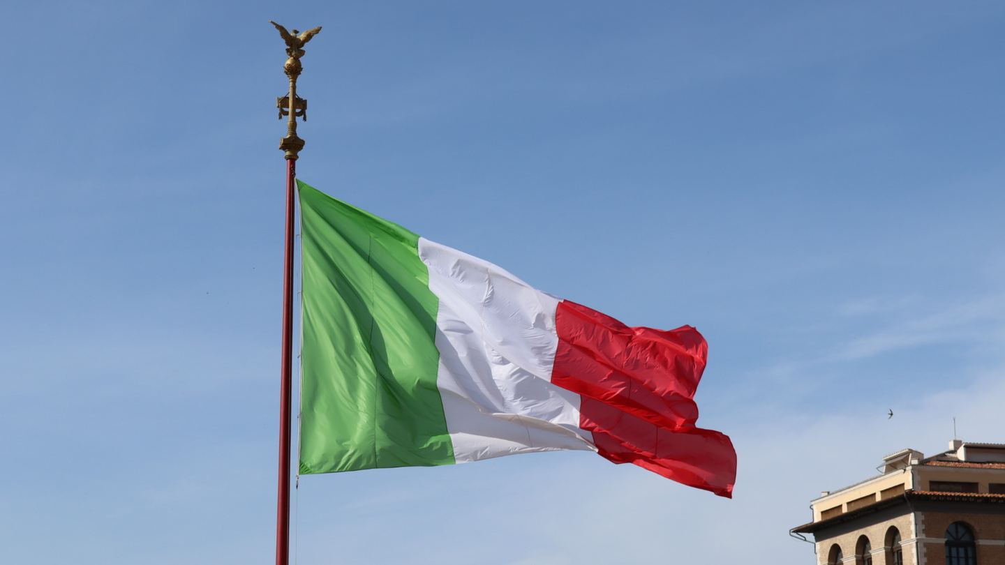 An Italian flag flying in front of the Vittoriano in Rome