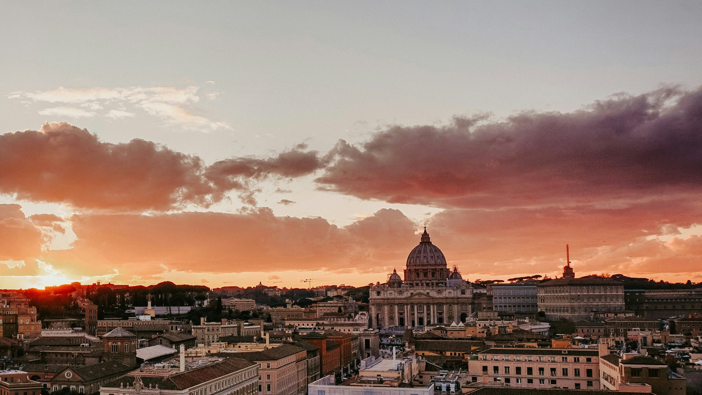 Warm sunset clouds above Rome's rooftops, the Tiber and the dome of St. Peter's Basilica