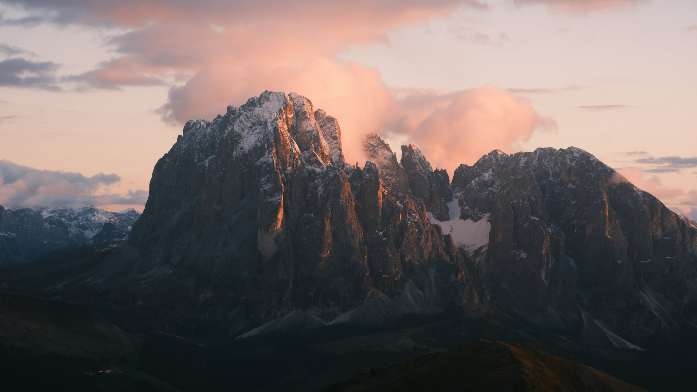 Rose-colored evening light above the snow-dusted Dolomite peaks at Seceda
