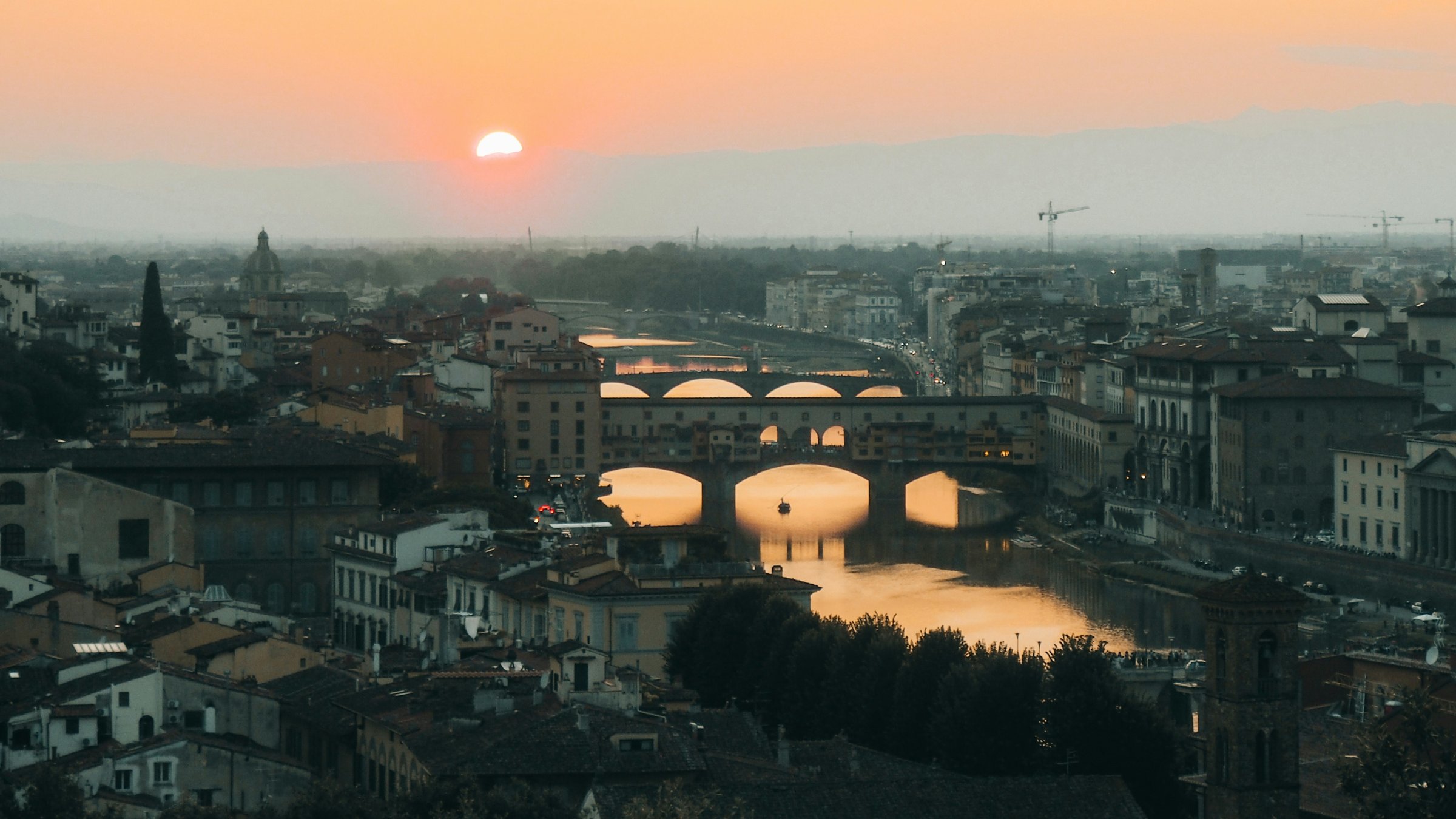 Warm light over Florence and the Arno, with Ponte Vecchio and a line of bridges