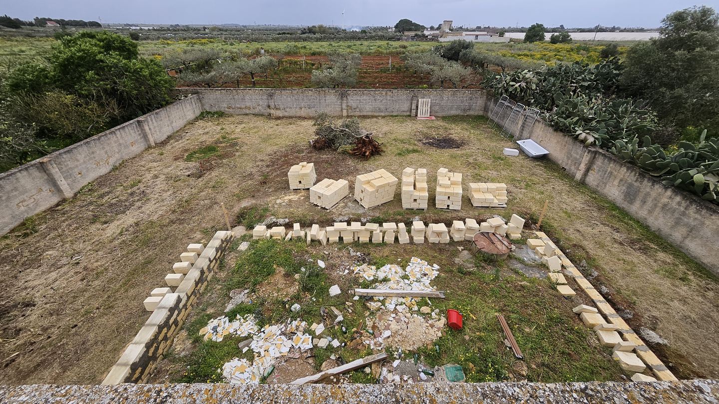 Aerial view of stone blocks and groundworks in the garden of the Operation Sicily villa