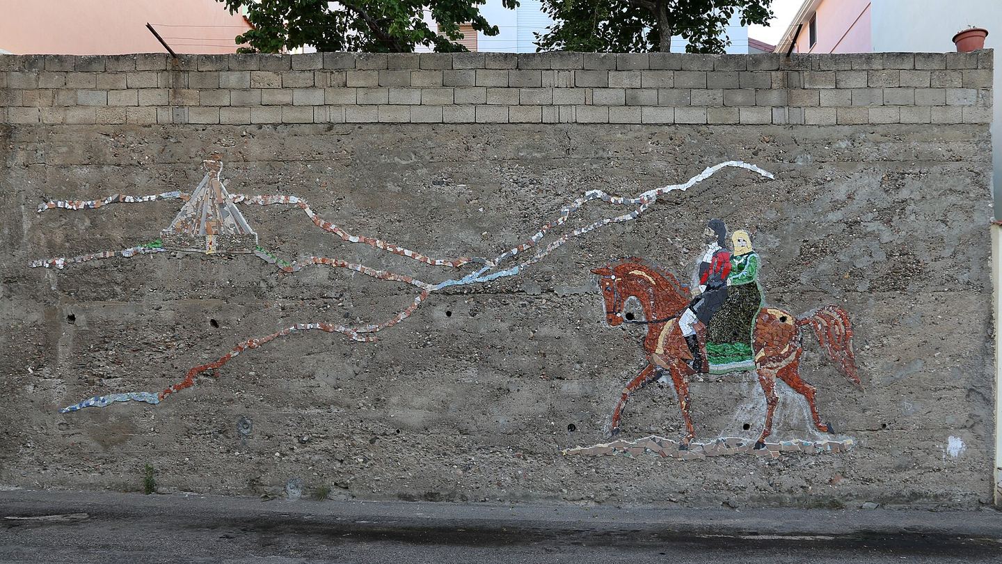 A political mural of two Sardinian riders on a street in Orgosolo