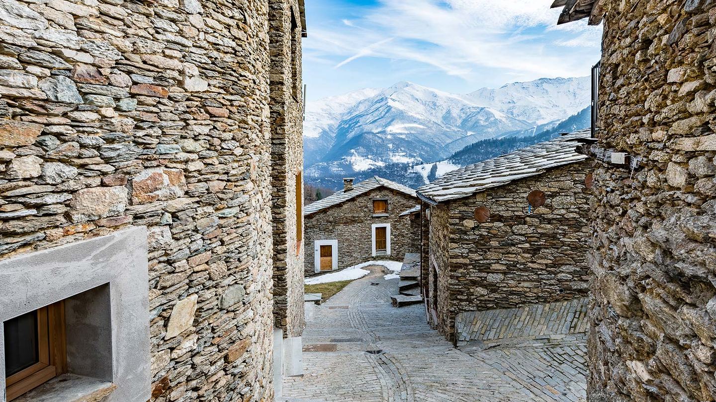 Stone houses and a mountain lane in Ostana beneath Monviso
