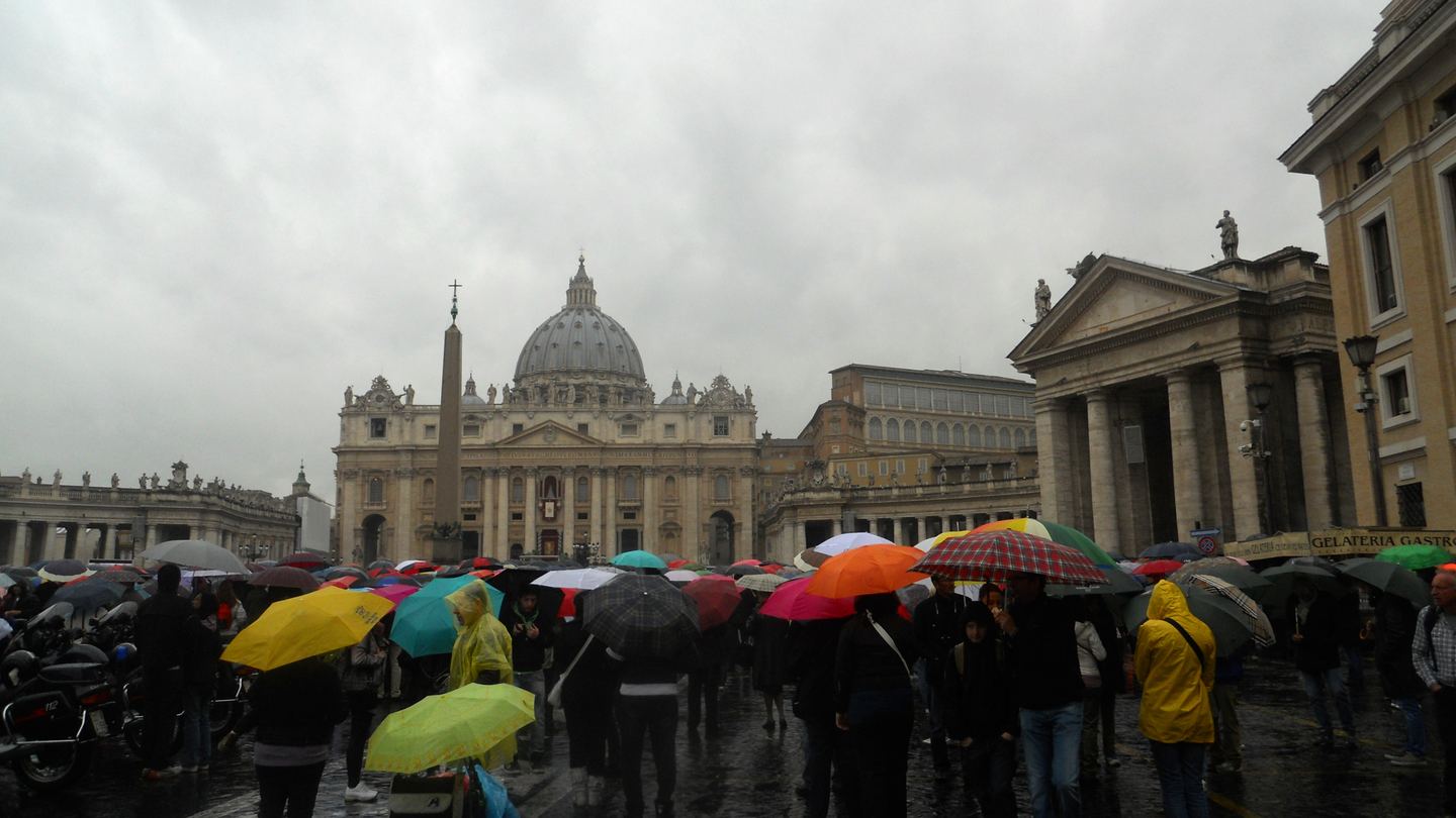 A rain-soaked Easter crowd with colorful umbrellas faces Saint Peter's Basilica in Vatican City in 2010